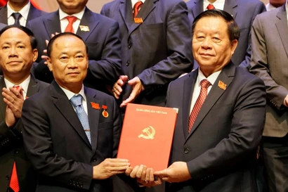 中央宣传与群众工作部部长阮仲义向蔡大玉同志授予决定。图自越通社