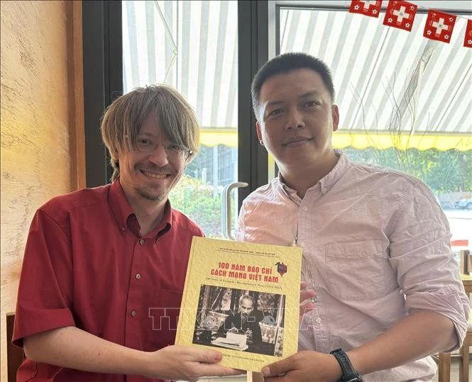 越通社记者向瑞士共产党总书记马西米利亚诺·阿伊赠送礼物。图自越通社