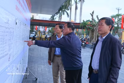 海进乡第三投票区的选民正在了解国会代表及各级人民议会代表候选人的相关信息。图自越通社