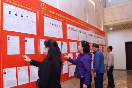 人们在河内第十三号选举单位查看候选人名单。图自越通社