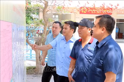 卡纳乡居民查看国会代表及各级人民代表候选人名单。图自越通社