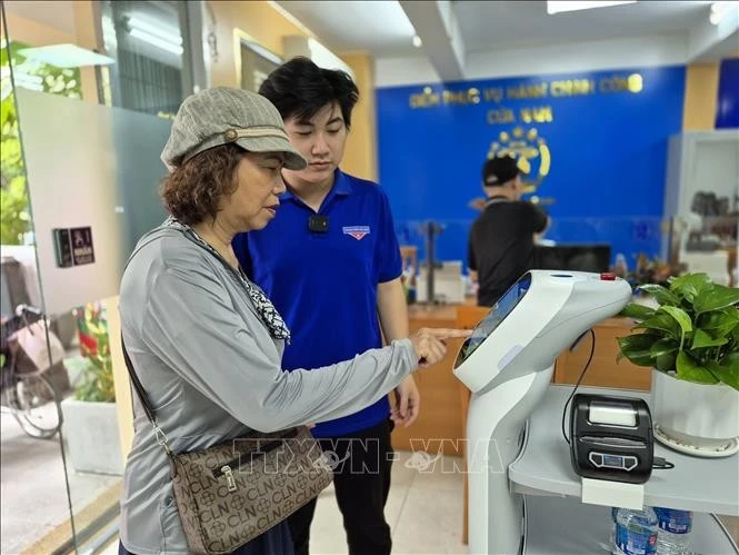 市民使用人工智能机器人来办理行政手续。图自越通社