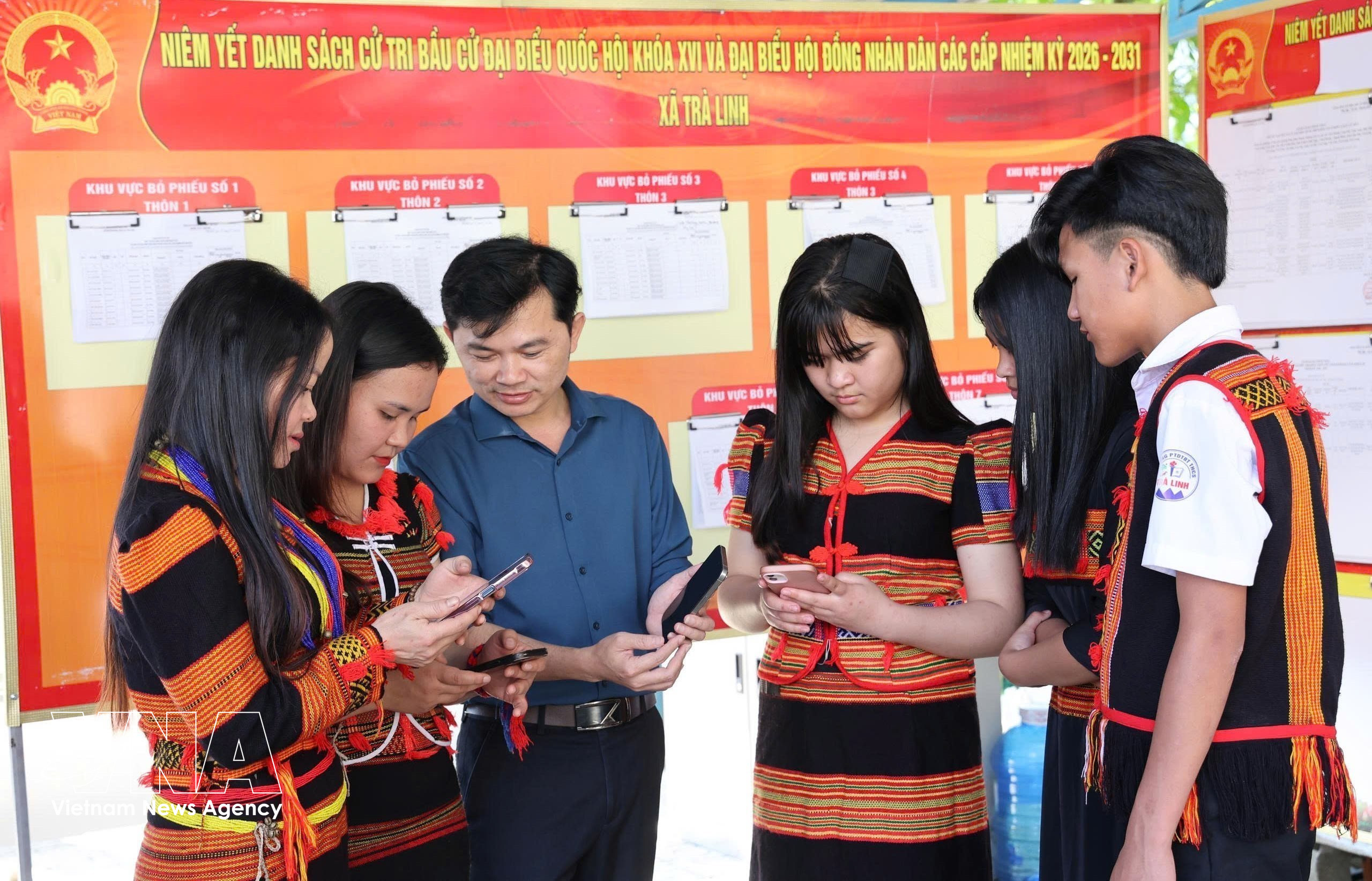 岘港市茶灵乡色当族同胞正在用手机查看有关第十六届国会及各级人民议会代表选举的视频和图表新闻，了解投票流程。图自越通社