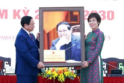 越通社社长武越庄向政府总理范明政赠送纪念照片。图自越通社