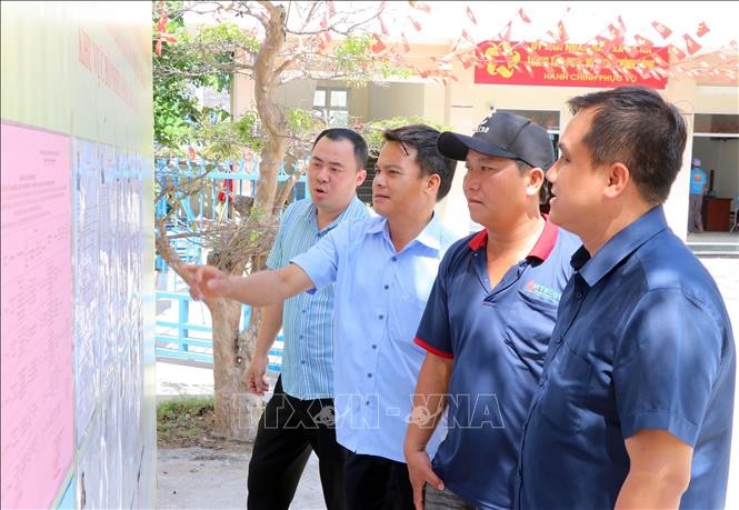 卡纳乡居民查看国会代表及各级人民代表候选人名单。图自越通社