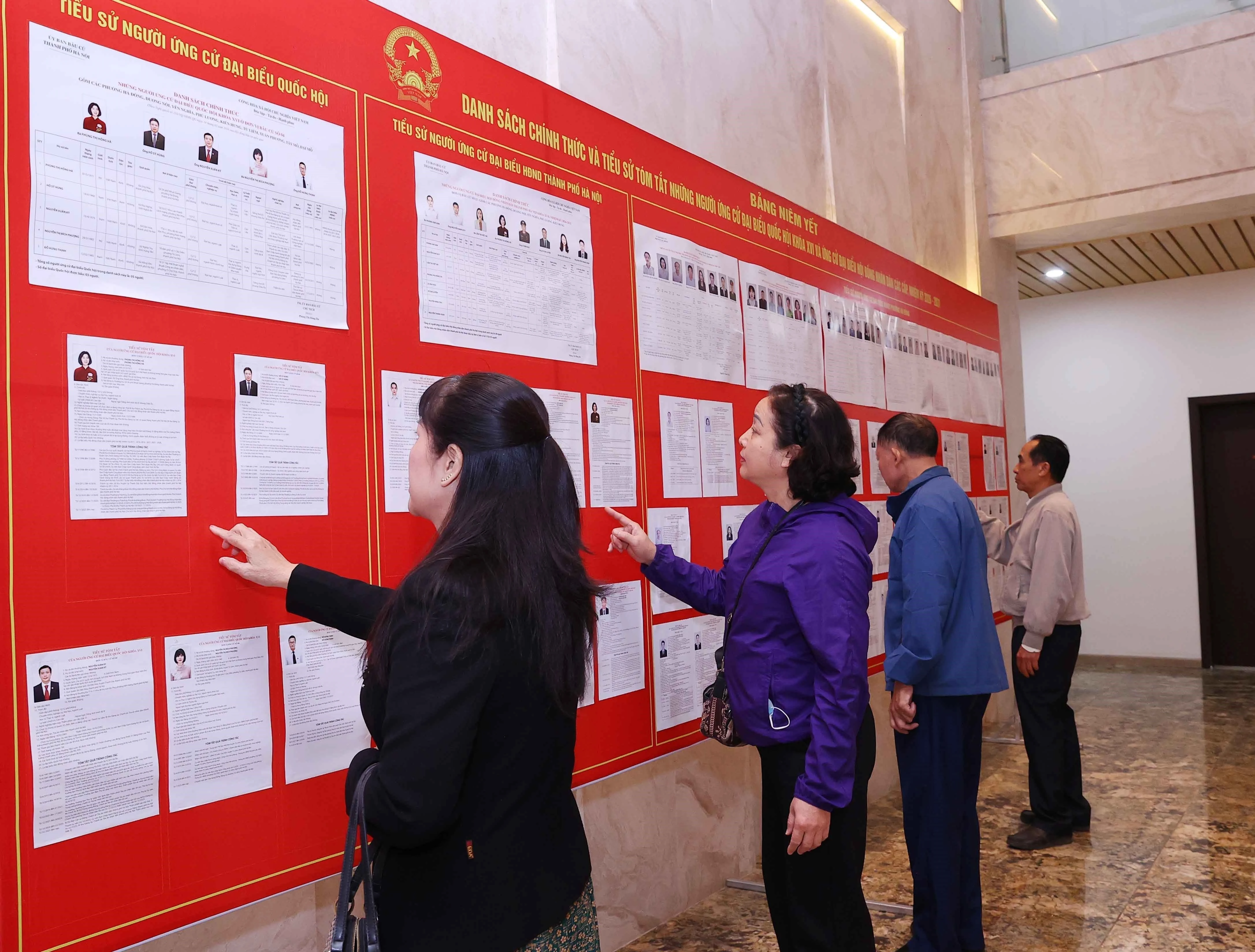 人们在河内第十三号选举单位查看候选人名单。图自越通社
