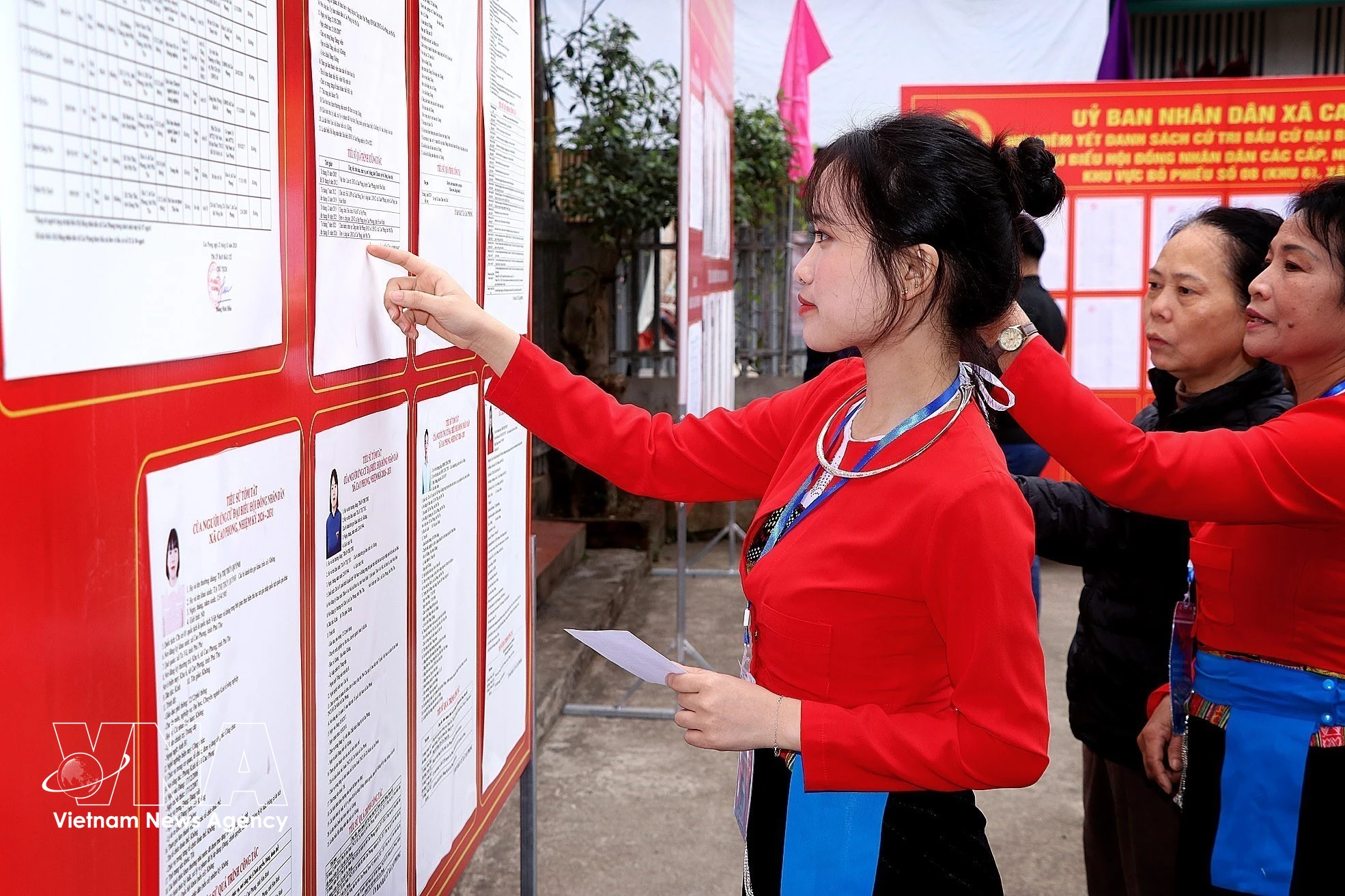 首次参加投票的芒族选民正在认真研究代表候选人的履历信息。图自越通社