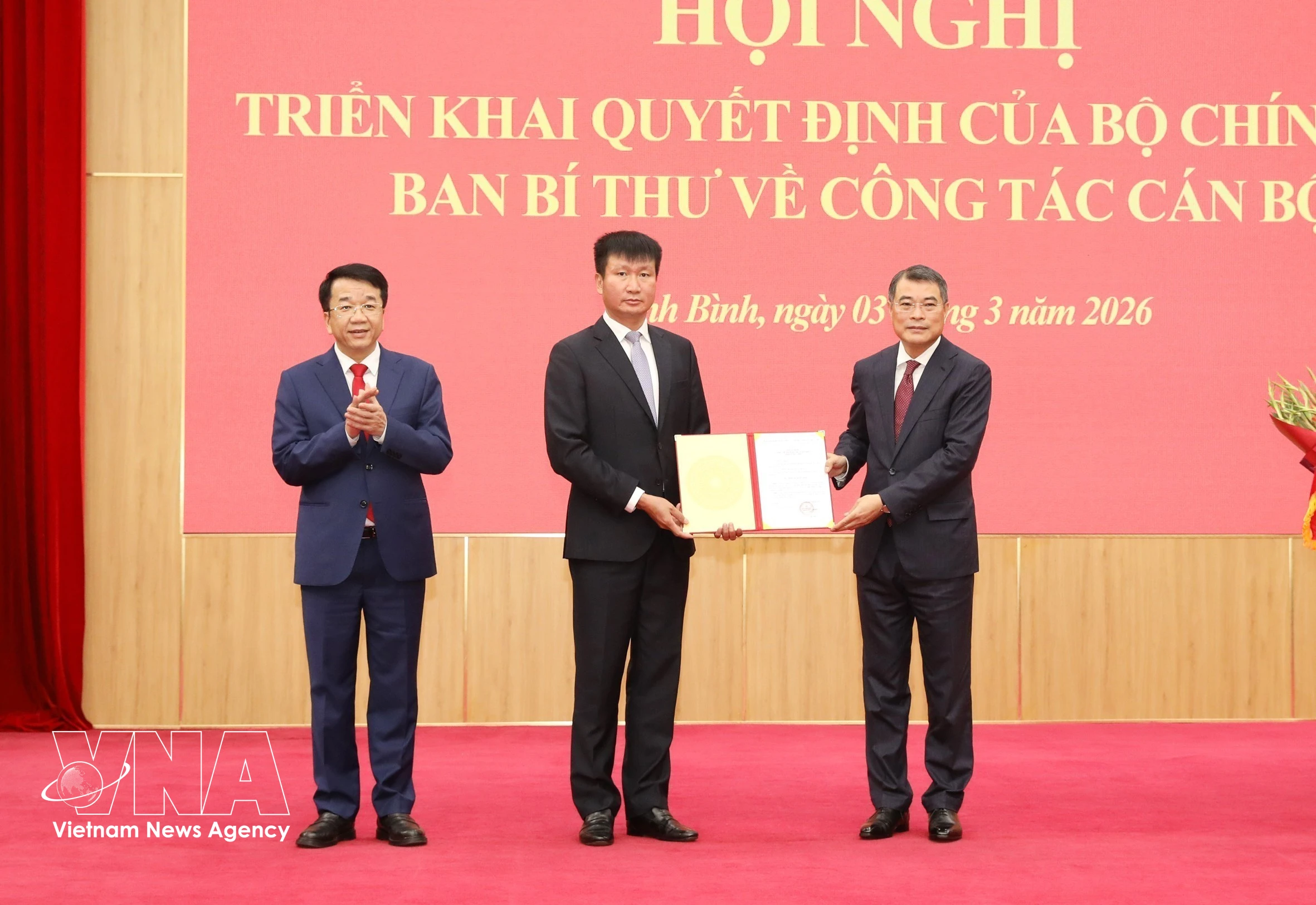 越共中央政治局委员、中央书记处书记、中央组织部部长黎明兴向陈辉俊同志颁发决定。图自越通社
