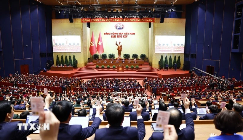 各位代表表决通过越共十四大决议。图自越通社