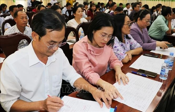代表们研究第十六届国会代表候选人资料。图自越通社