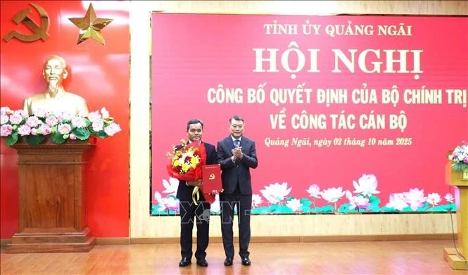 越共中央政治局委员、中央书记处书记、中央组织部部长黎明兴向越共中央委员、民族与宗教部常务副部长胡文年同志颁发任命书。图自越通社