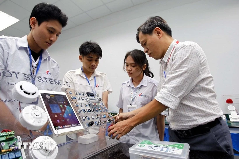 胡志明市工业大学电子技术学院教师在物联网与人工智能实验室指导学生学习与研究。图自越通社