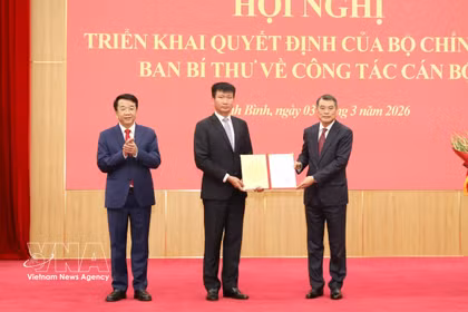 越共中央政治局委员、中央书记处书记、中央组织部部长黎明兴向陈辉俊同志颁发决定。图自越通社