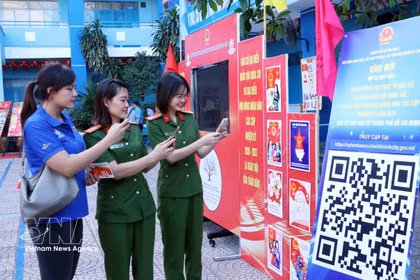 胡志明市年轻选民通过扫描二维码（QR码）参加《选举法》在线知识竞赛。图自越通社