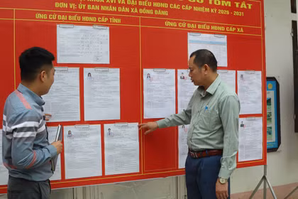 越南谅山省同登边境乡南关村党支部党员，在候选人名单公示处进行宣传与指导。图自越通社