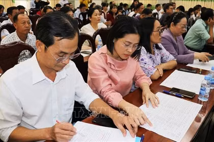 代表们研究第十六届国会代表候选人资料。图自越通社