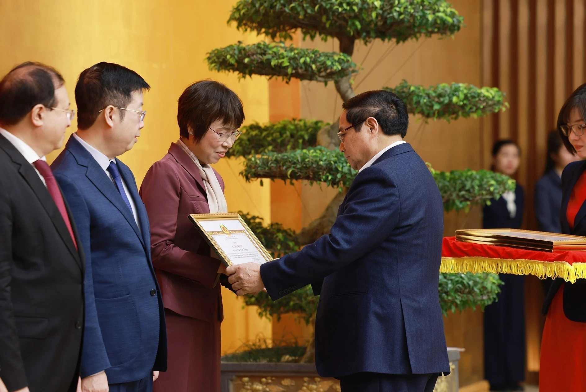 政府党委书记、政府总理范明政向越通社社长武越庄颁发政府党委的奖状。图自越通社